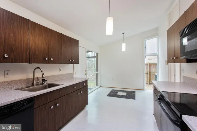 a kitchen with a sink appliances and cabinets