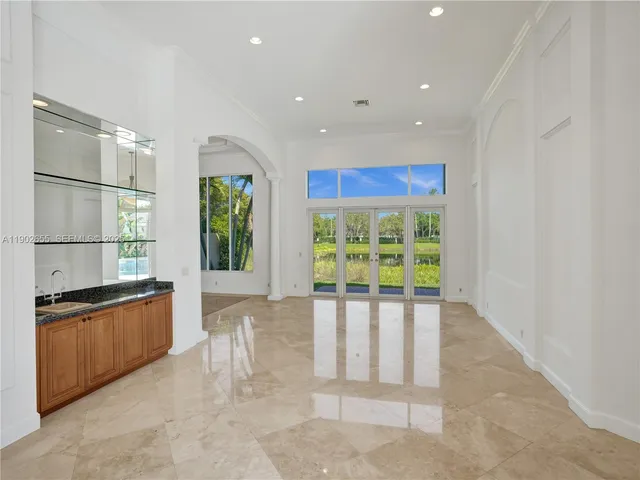 a kitchen with stainless steel appliances granite countertop a stove a sink a refrigerator and a window