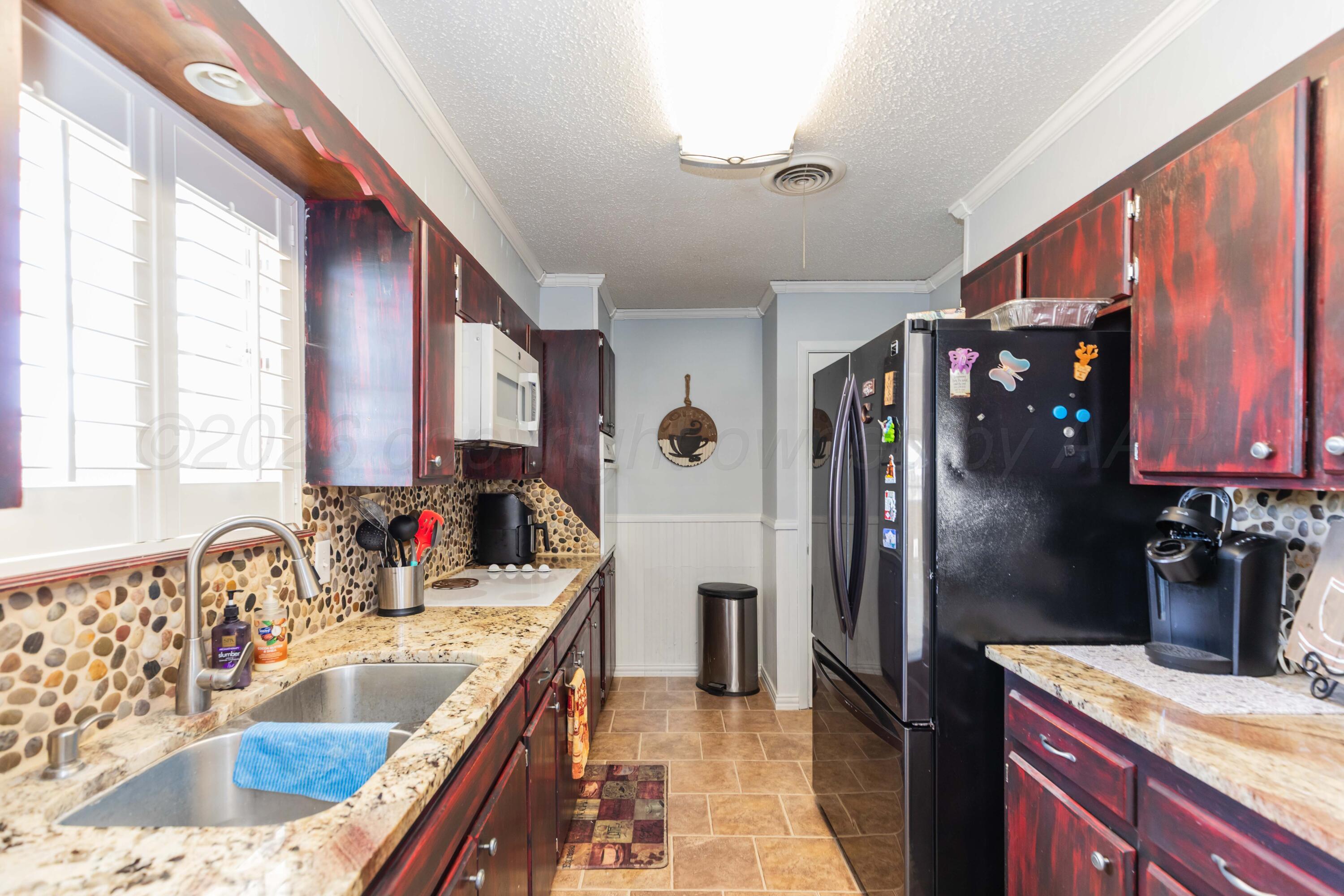 4800 South Austin Street Amarillo, TX 79110 - Photo 11 of 29 a kitchen with a sink refrigerator and cabinets