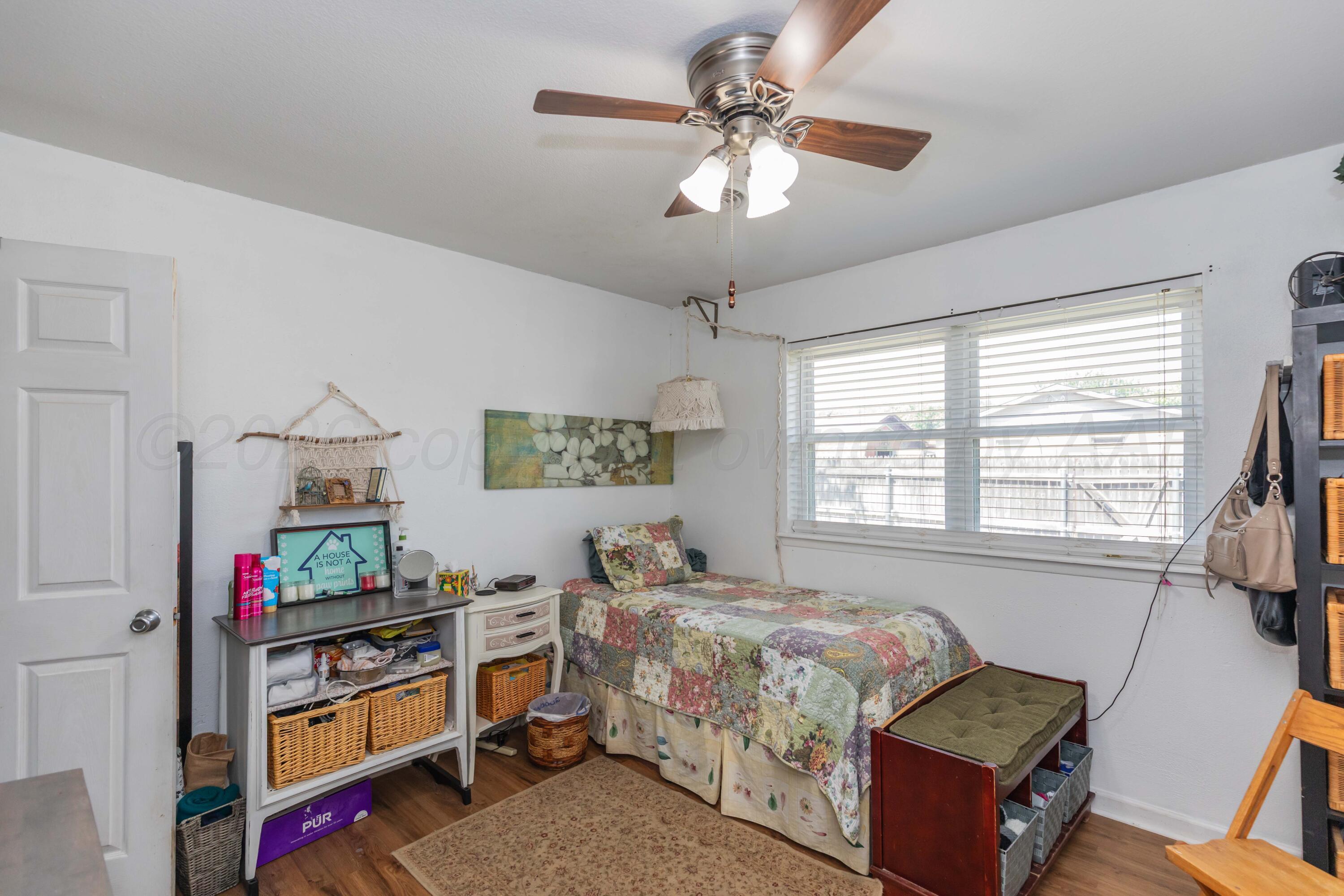 4800 South Austin Street Amarillo, TX 79110 - Photo 15 of 29 a bedroom with a bed a window and a chandelier