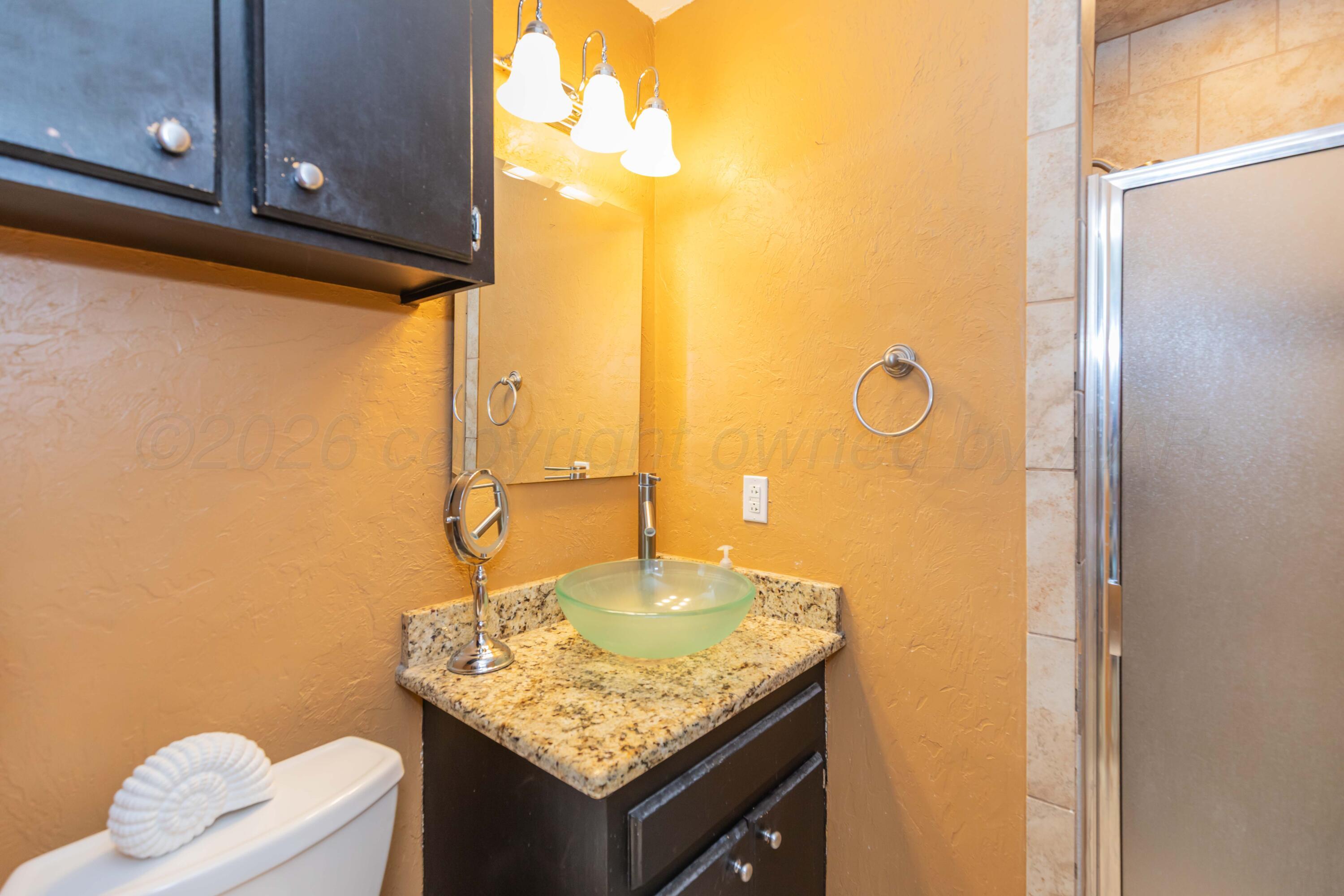 4800 South Austin Street Amarillo, TX 79110 - Photo 21 of 29 a bathroom with a granite countertop sink and a mirror