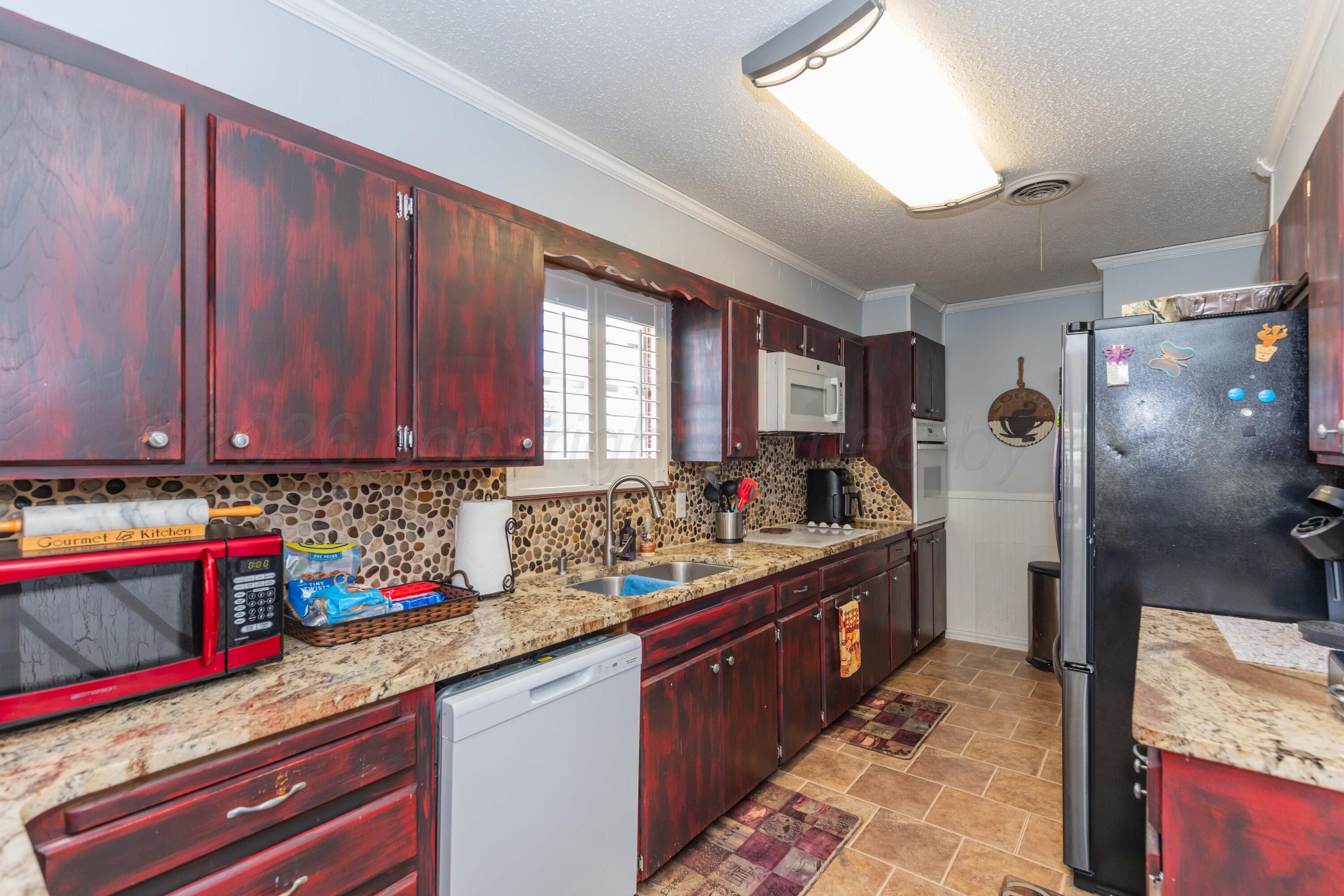 4800 South Austin Street Amarillo, TX 79110 - Photo 10 of 29 a kitchen with stainless steel appliances granite countertop a sink stove and refrigerator