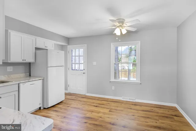 a view of a kitchen with a sink cabinet a refrigerator and cabinets