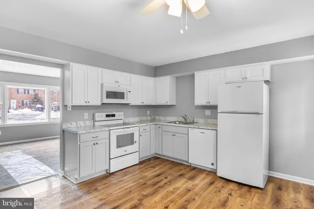 a kitchen with white cabinets and white appliances