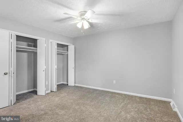 an empty room with chandelier fan