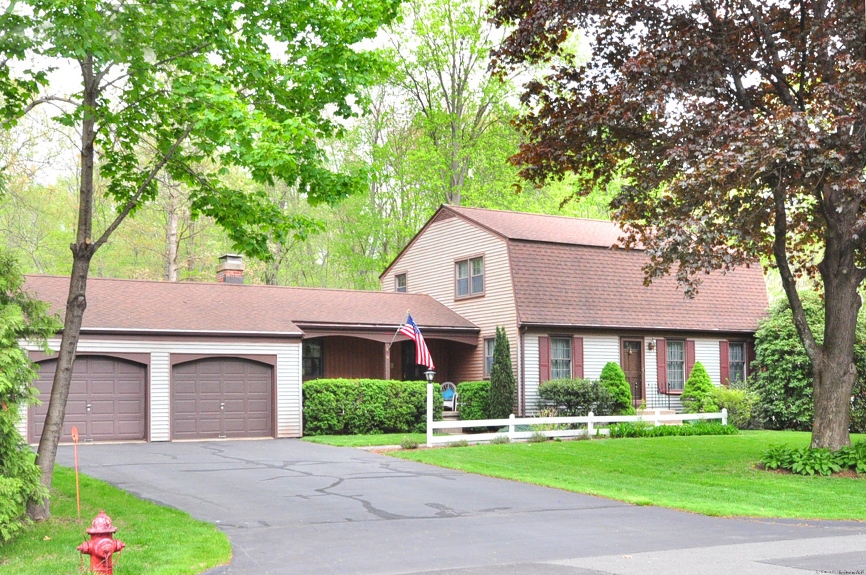 a front view of a house with a garden and trees