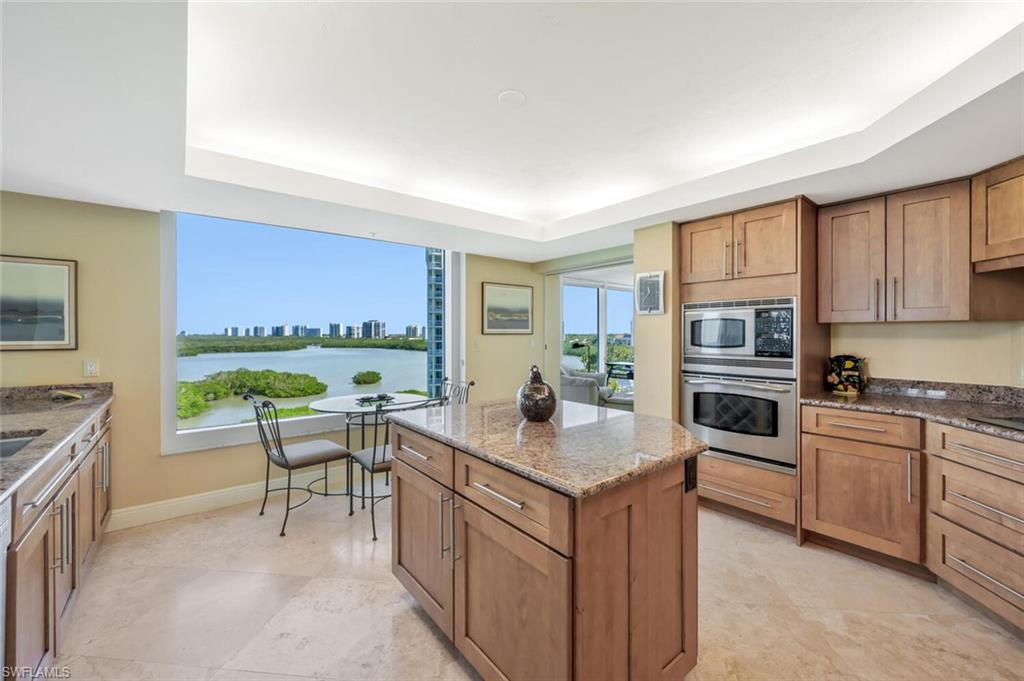 20 Seagate Drive, Unit 803 Naples, FL 34103 - Photo 12 of 44 a kitchen with a stove a sink and a refrigerator