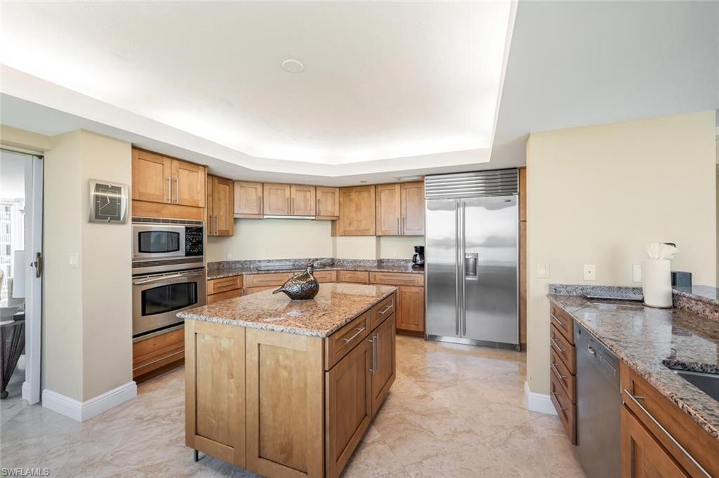 20 Seagate Drive, Unit 803 Naples, FL 34103 - Photo 14 of 44 a kitchen with stainless steel appliances granite countertop a stove a sink and a refrigerator