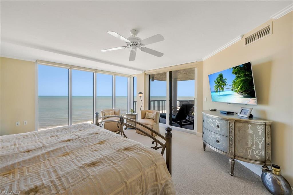 20 Seagate Drive, Unit 803 Naples, FL 34103 - Photo 22 of 44 a bedroom with a bed and large windows
