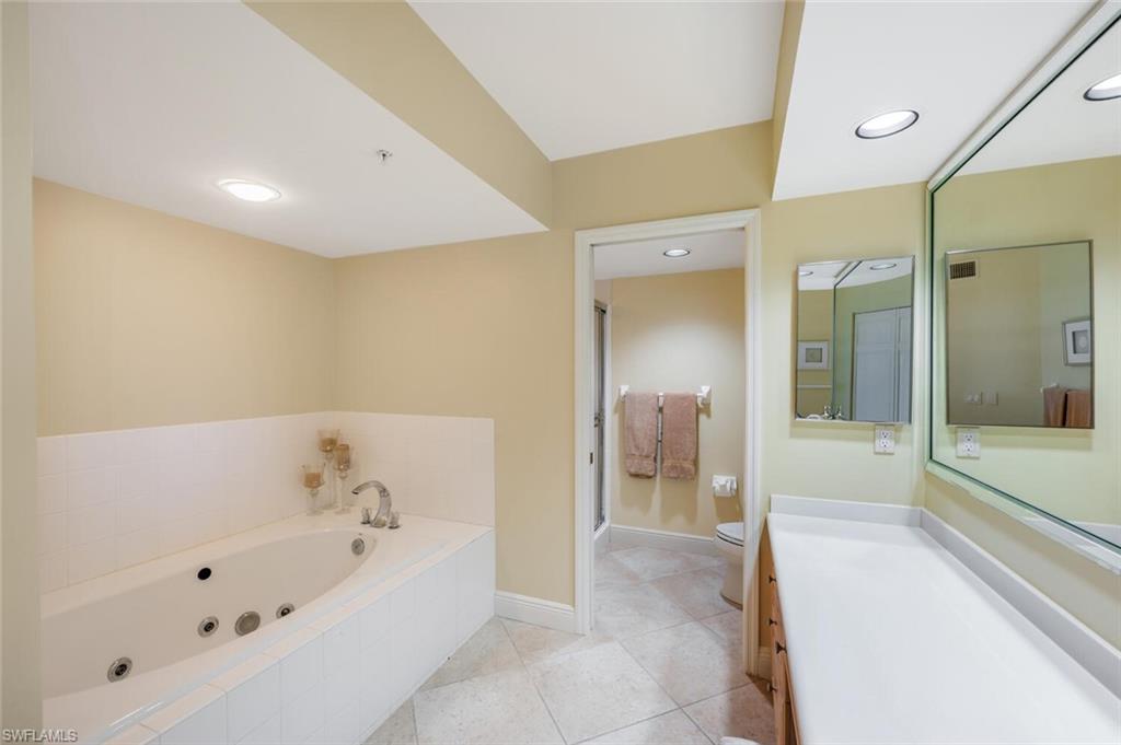 20 Seagate Drive, Unit 803 Naples, FL 34103 - Photo 26 of 44 a bathroom with a bathtub and a shower
