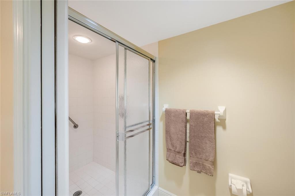 20 Seagate Drive, Unit 803 Naples, FL 34103 - Photo 27 of 44 a bathroom with a glass shower door and a bathroom sink