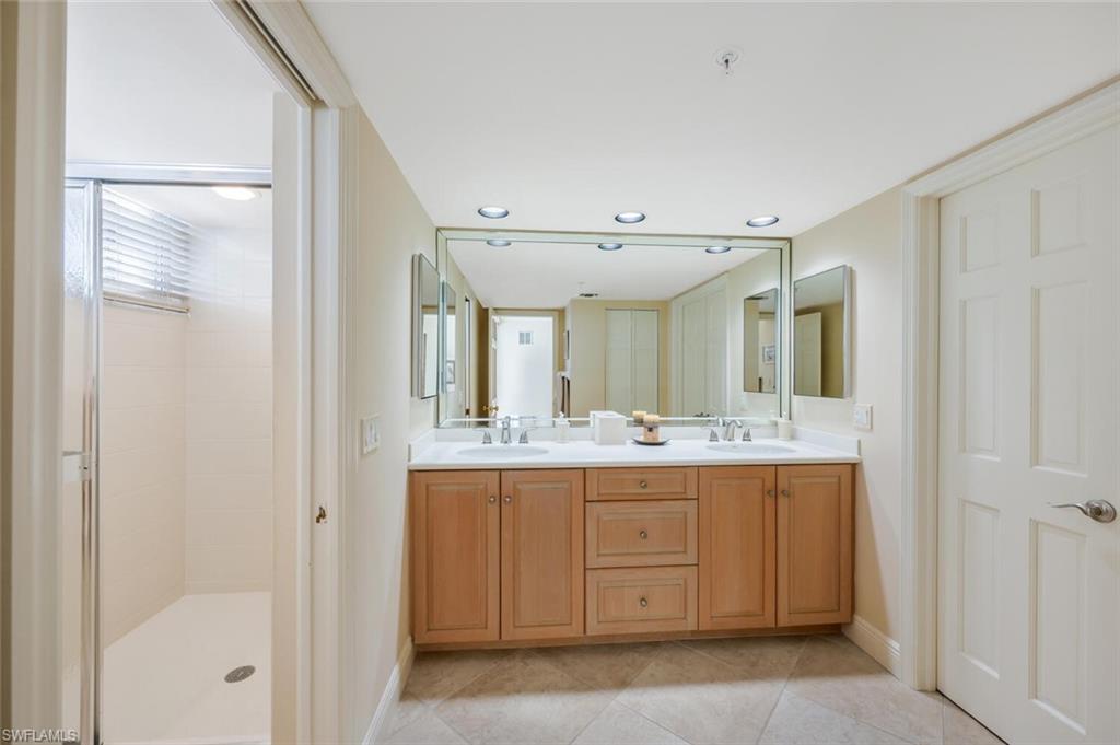 20 Seagate Drive, Unit 803 Naples, FL 34103 - Photo 32 of 44 a bathroom with a granite countertop sink and a mirror