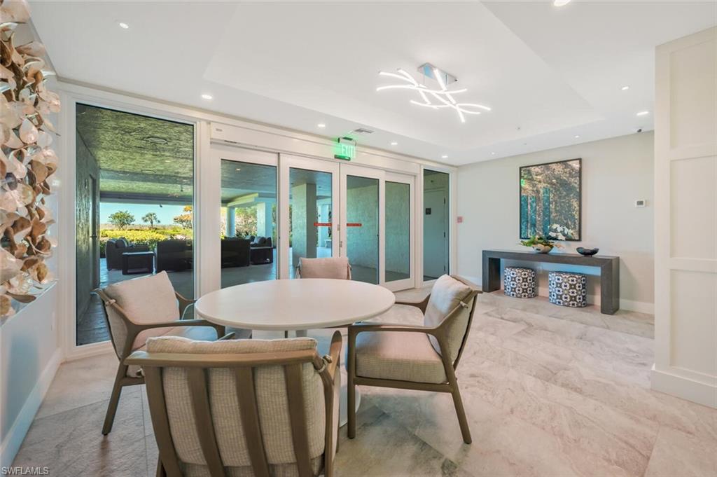 20 Seagate Drive, Unit 803 Naples, FL 34103 - Photo 42 of 44 a dining room with furniture a chandelier and wooden floor