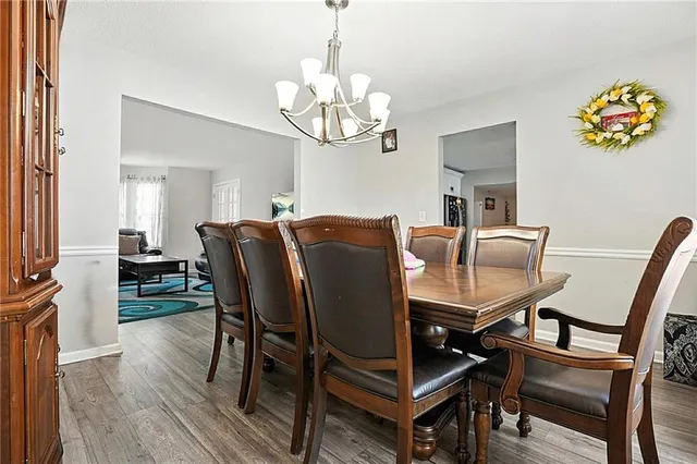 a view of a dining room with furniture a chandelier and wooden floor