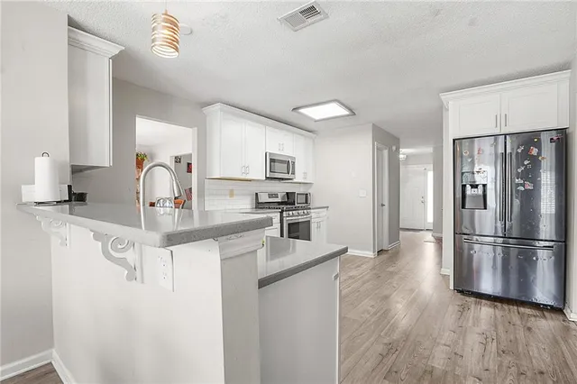 a kitchen with stainless steel appliances granite countertop a refrigerator and a sink