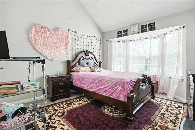 a bed sitting in a bedroom next to a window