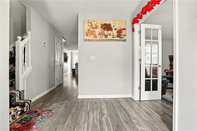 a view of a hallway with wooden floor and a living room