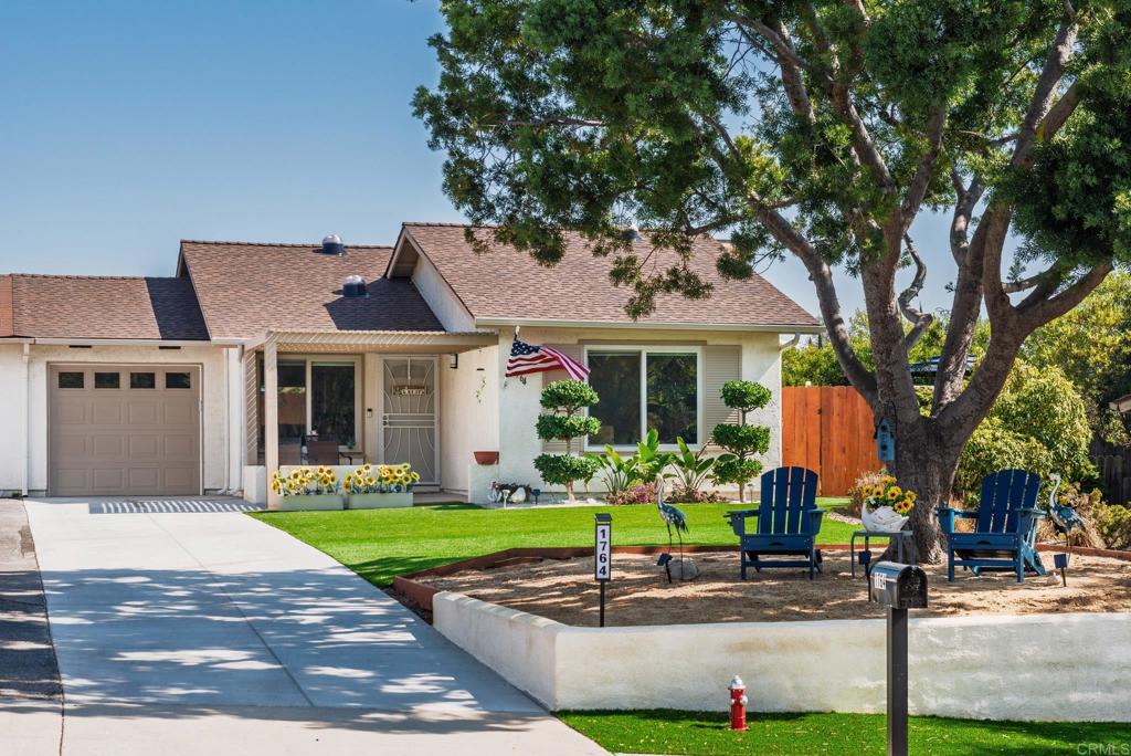 a front view of a house with a garden and trees