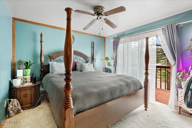 a bedroom with a bed a flat screen tv and a large window