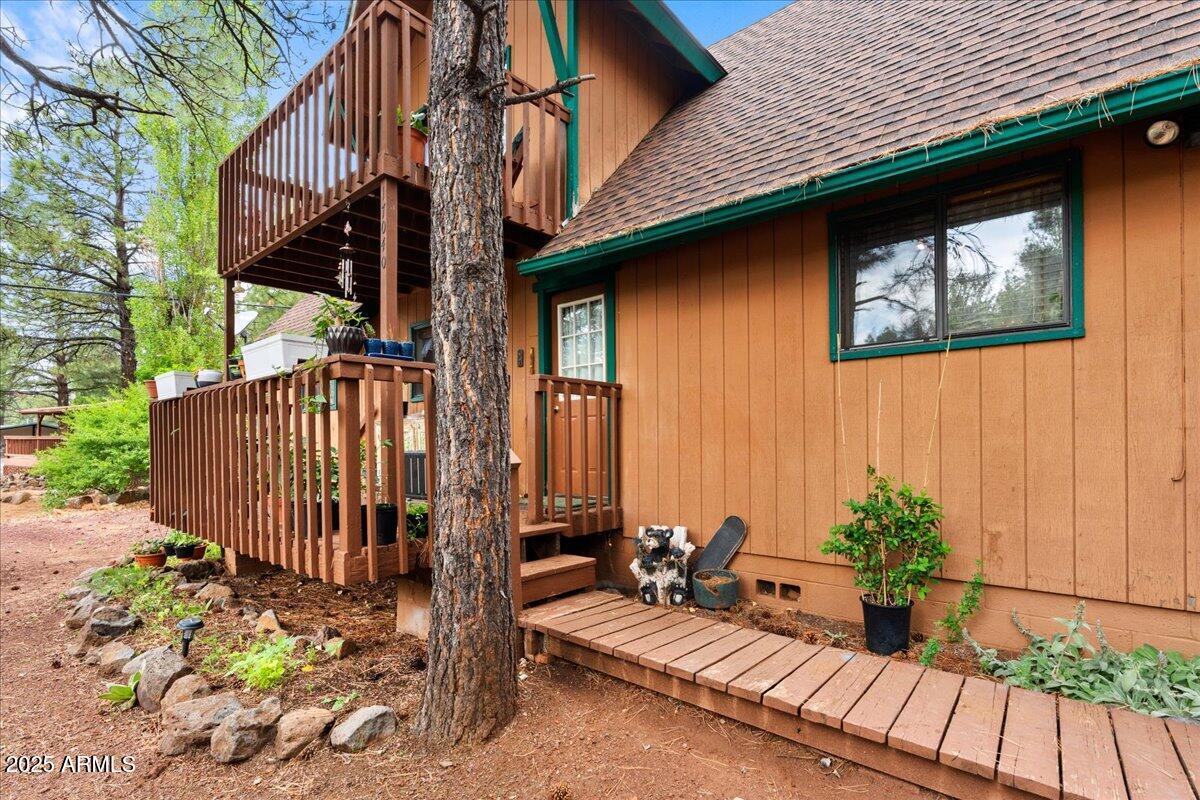 17040 Bowstring Road Munds Park, AZ 86017 - Photo 4 of 18 a view of a house with a wooden bench next to a road