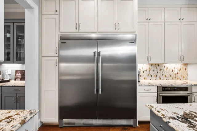 a view of a dining room and livingroom with furniture wooden floor a chandelier
