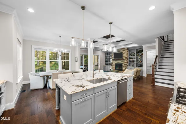 a dining room with wooden floor a chandelier a wooden table and chairs