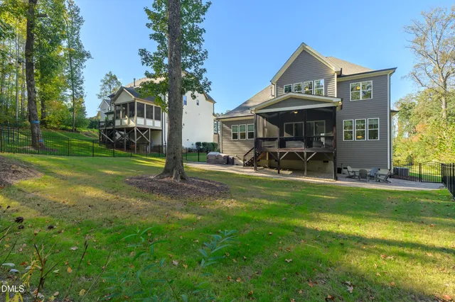 an aerial view of a house with swimming pool and large trees