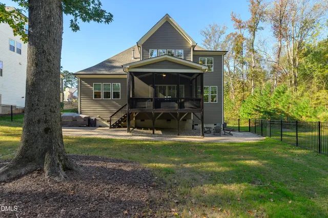 an aerial view of a house with swimming pool and large trees