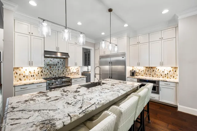 a kitchen with stainless steel appliances granite countertop a kitchen island a stove and a refrigerator