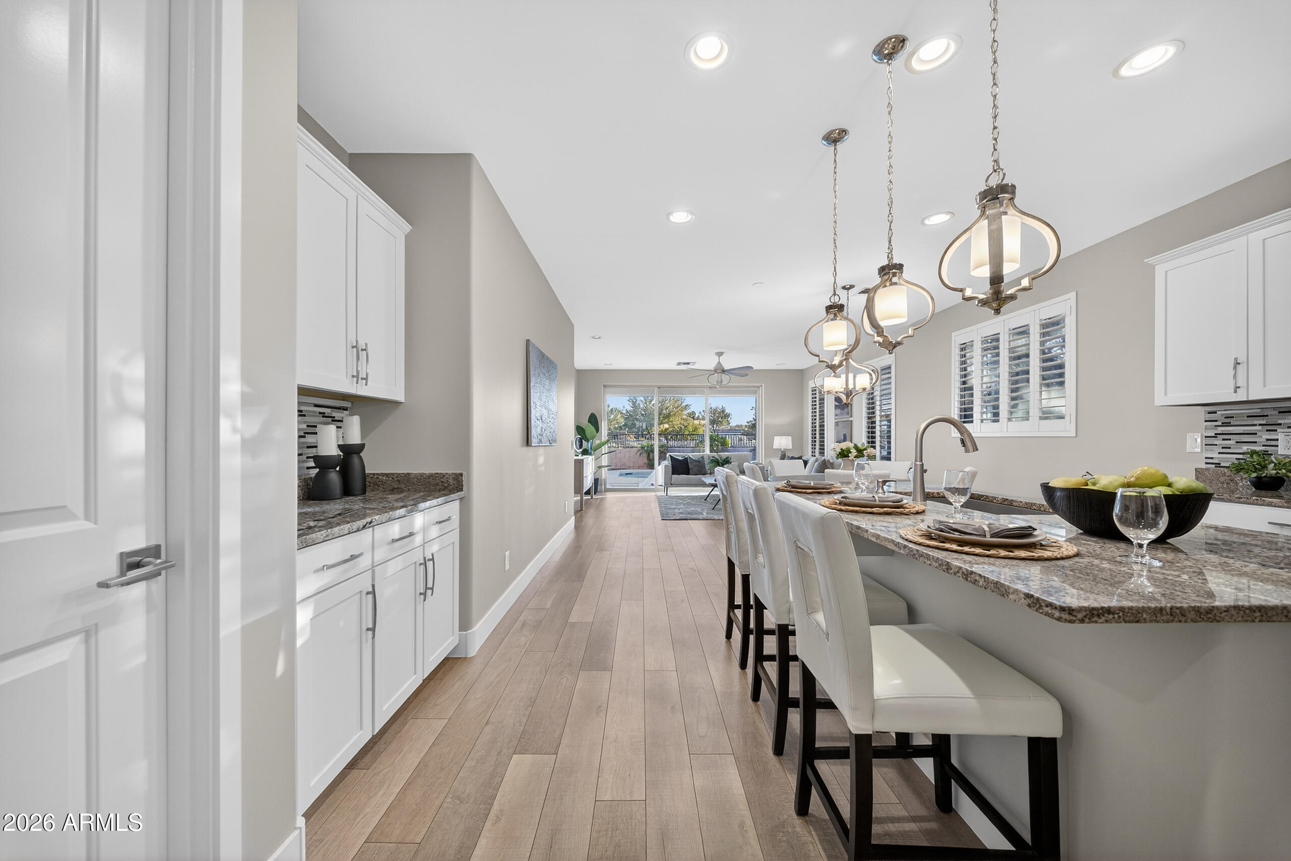 5067 South Girard Street Gilbert, AZ 85298 - Photo 4 of 15 a kitchen with stainless steel appliances kitchen island granite countertop a stove a sink a refrigerator and white cabinets with wooden floor