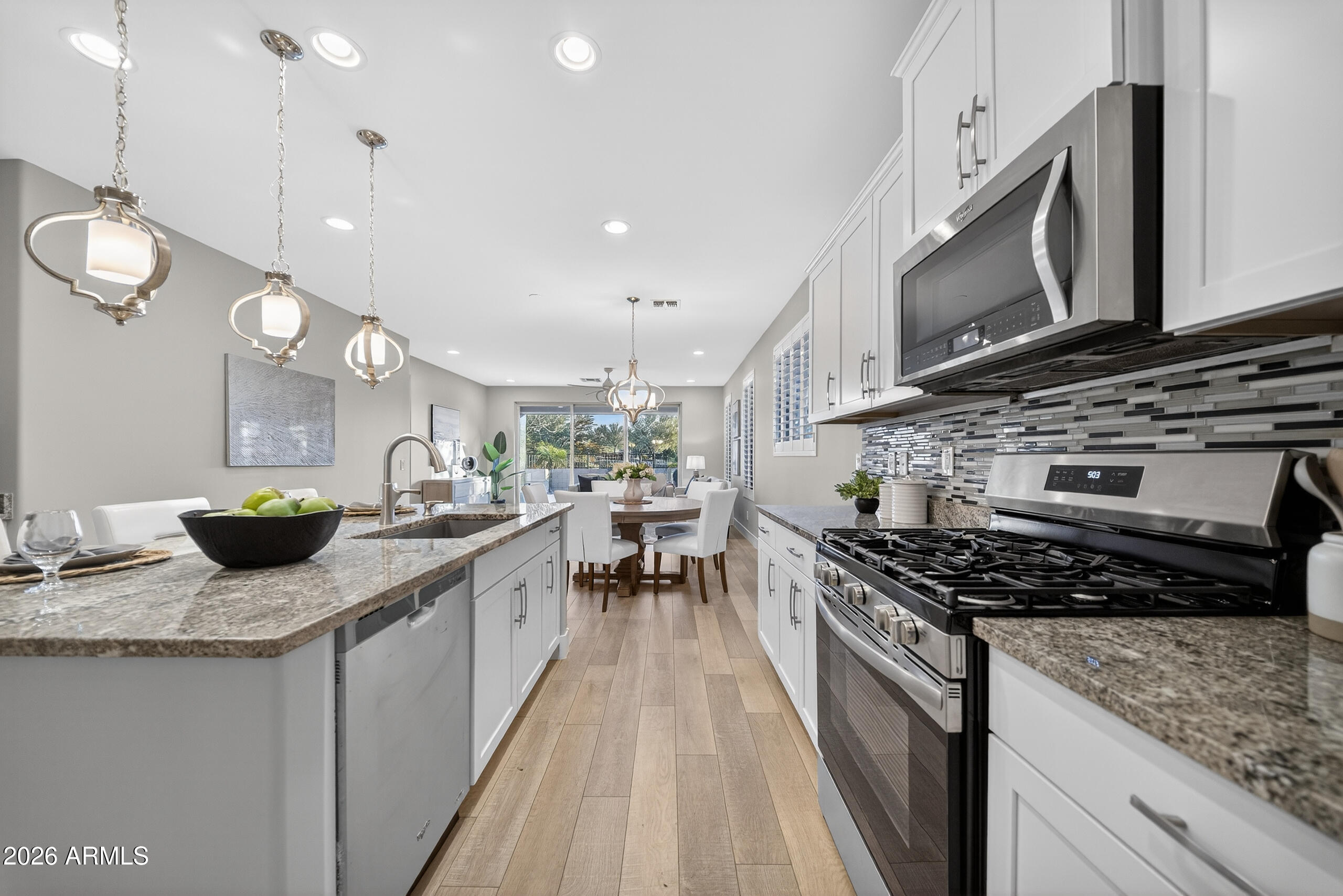 5067 South Girard Street Gilbert, AZ 85298 - Photo 6 of 15 a kitchen with stainless steel appliances granite countertop a stove a sink and a microwave