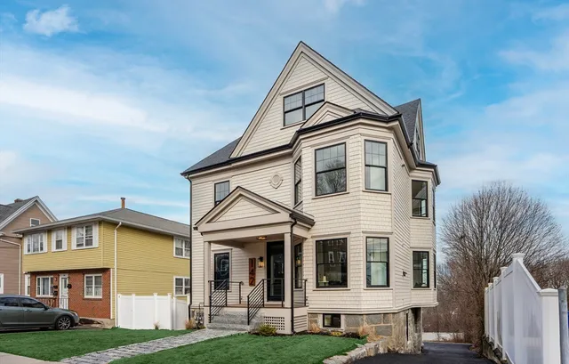 a front view of a house with a yard and trees