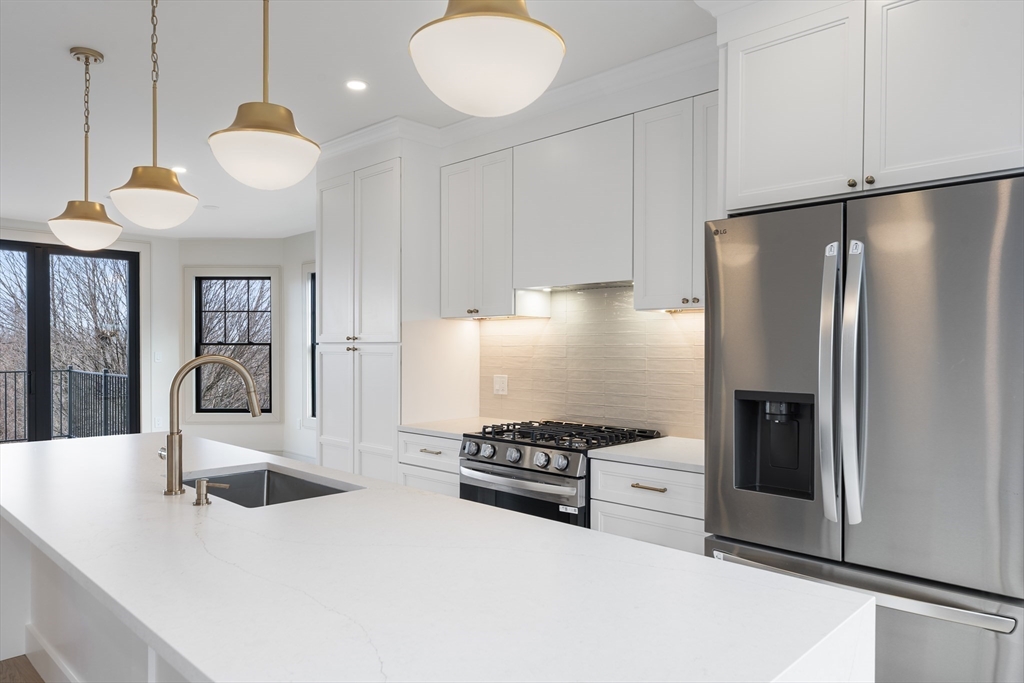142 Metropolitan Avenue, Unit 2 Boston, MA 02131 - Photo 3 of 13 a kitchen with stainless steel appliances granite countertop a sink a stove and a refrigerator