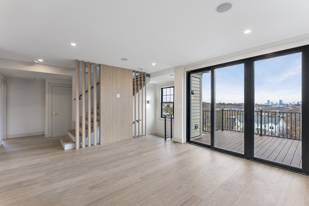 142 Metropolitan Avenue, Unit 2 Boston, MA 02131 - Photo 4 of 13 an empty room with wooden floor and windows