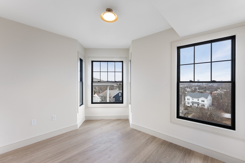 142 Metropolitan Avenue, Unit 2 Boston, MA 02131 - Photo 8 of 13 an empty room with windows and entrance