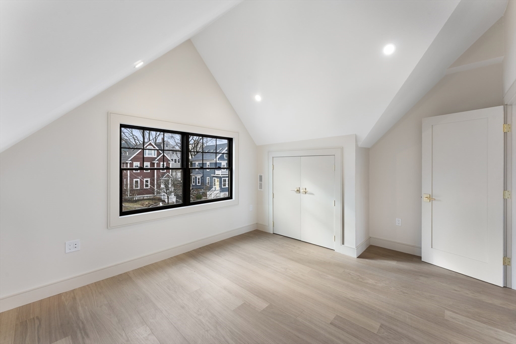 142 Metropolitan Avenue, Unit 2 Boston, MA 02131 - Photo 9 of 13 an empty room with wooden floor and windows