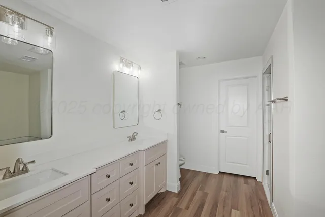 a spacious bathroom with a double vanity sink a mirror and a shower