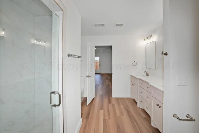 a spacious bathroom with a double vanity sink and mirror