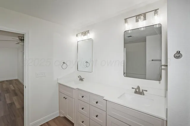 a bathroom with double vanity sink and mirror