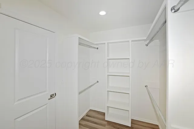 a view of walk in closet with empty racks
