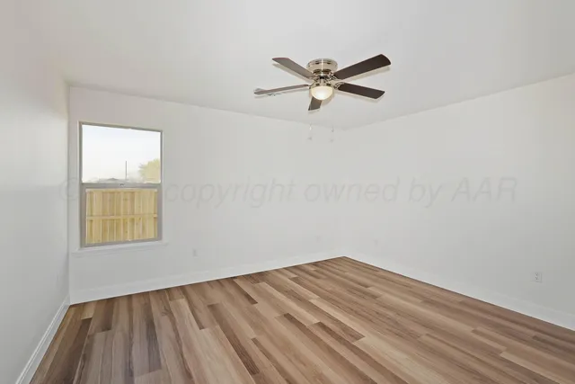 a view of a room with wooden floor and window