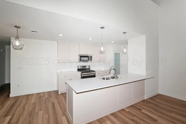 a view of kitchen with sink and refrigerator