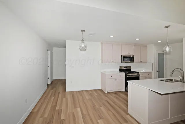 a view of a kitchen with sink stainless steel appliances and wooden floor