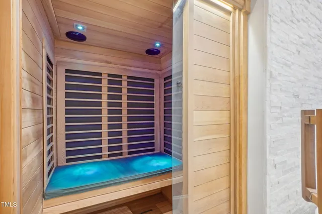 a spacious bedroom with a bed a dresser and a large window