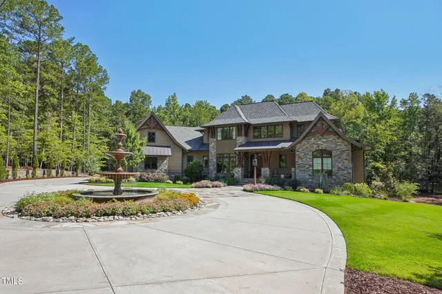 a front view of a house with a yard and potted plants