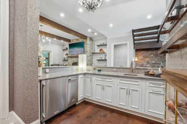 a kitchen with stainless steel appliances kitchen island granite countertop a table chairs in it and wooden floors