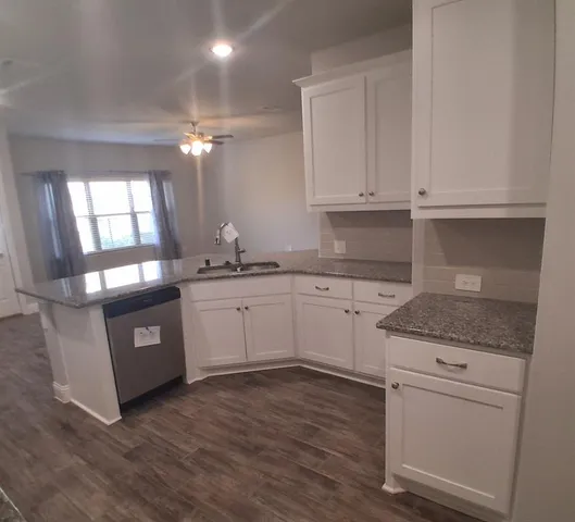 a kitchen with granite countertop white cabinets and white appliances