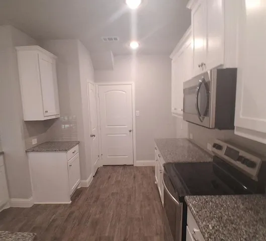 a kitchen with white cabinets sink and refrigerator