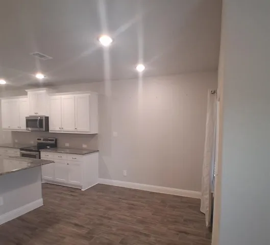 a view of kitchen with wooden floor and electronic appliances