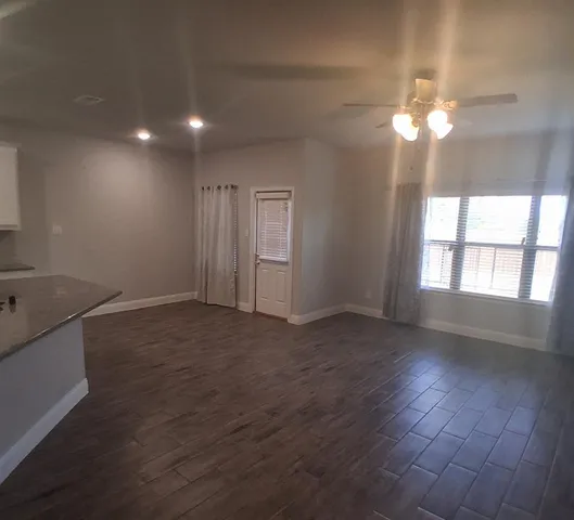 a view of wooden floor and chandelier fan in an empty room